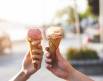 two people holding out ice cream cones